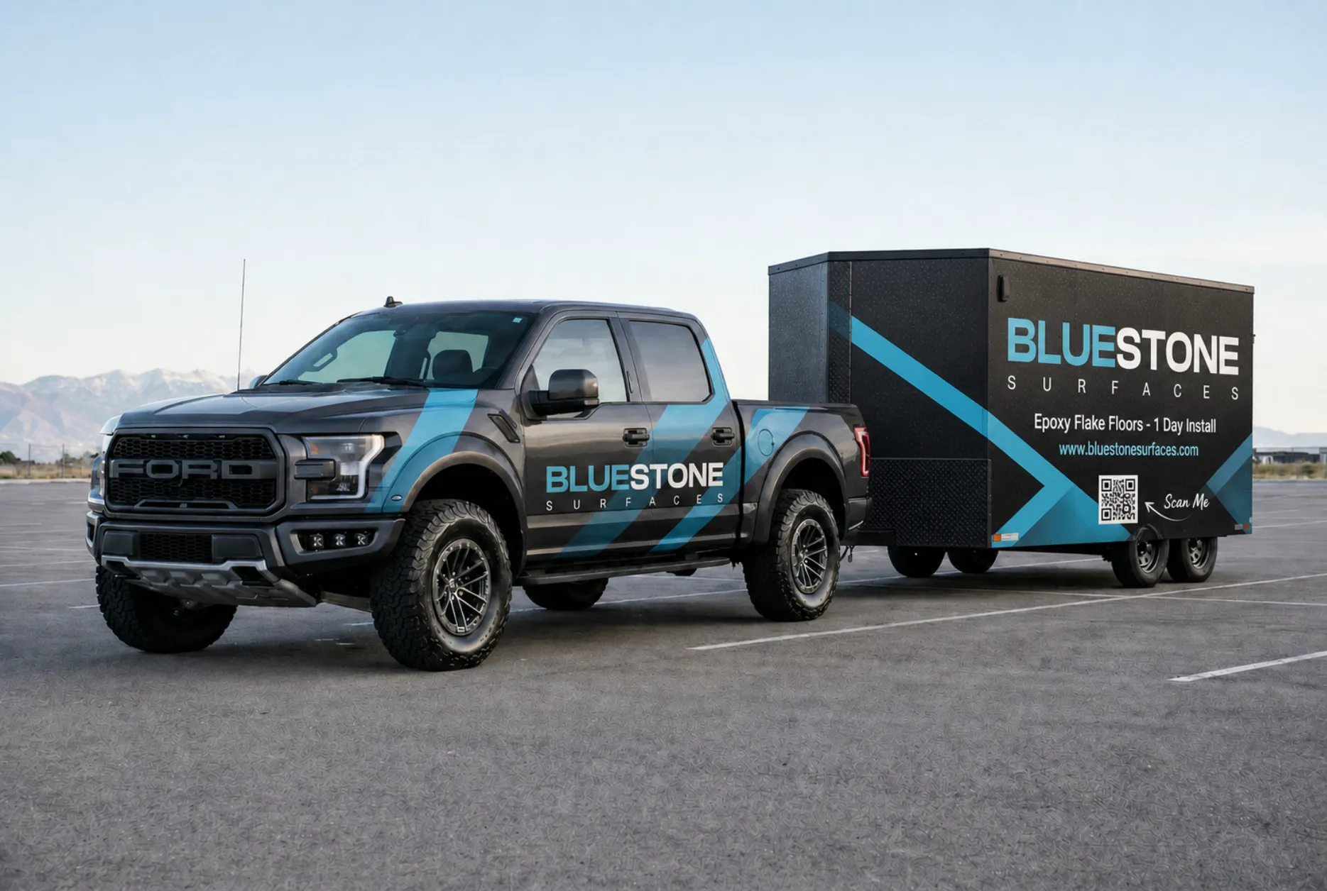 The Bluestone Surfaces truck and job trailer parked in front of the Wasatch Mountains